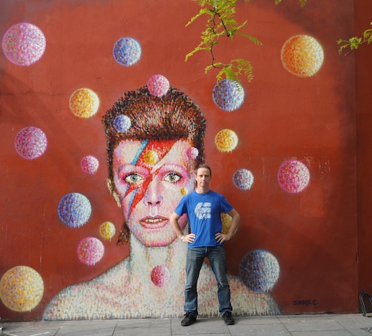 JimmyC with the portrait of David Bowie on the side of Morley's in Brixton 