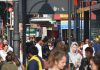 Crowds of people walk down Brixton Road in the sunshine
