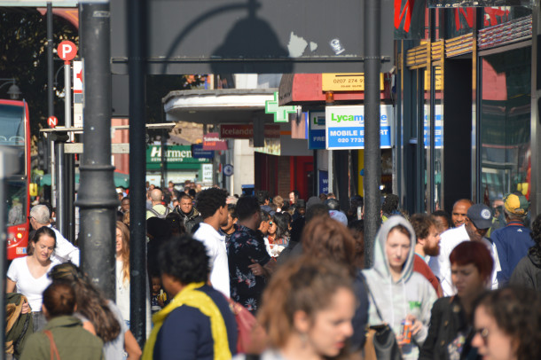 Crowds of people walk down Brixton Road in the sunshine