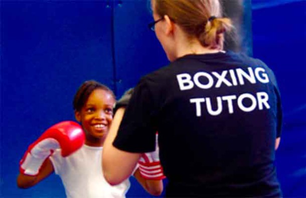 Dwaynamics boxing coach helping a schoolgirl to practice jabs and crosses