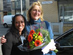 Melissa Nicholas (left) Family Co-ordinator at Home-Start Lambeth presenting flowers to Sophia Ruck for her work volunteering