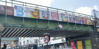 Bridge over Brixton Road with BE OUR Guest slogan