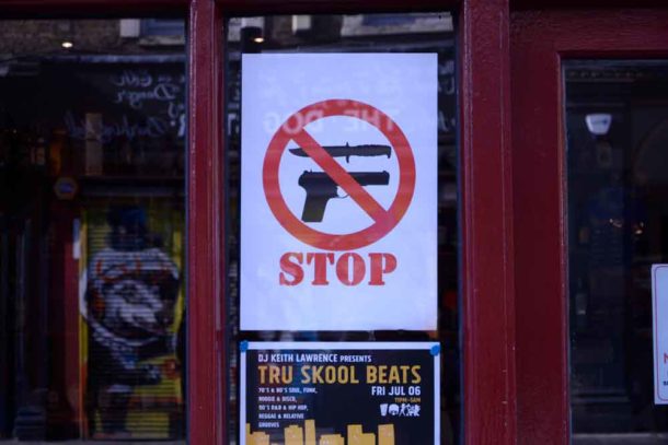 Stop knife gun sign in Brixton shop window