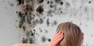 Woman looking at damp on wall