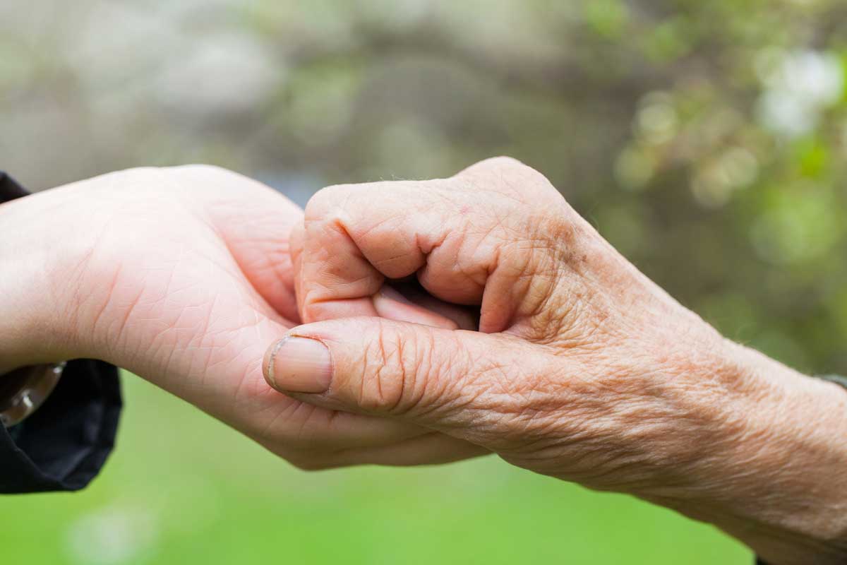 photo of two hands together to illustrate carer support