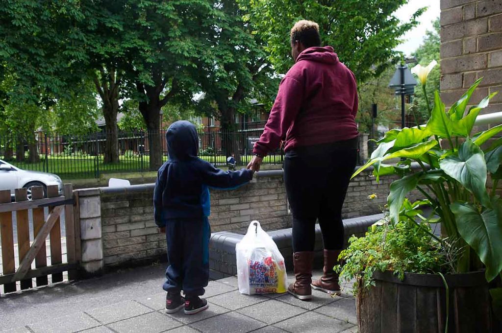 Mother and child with foodbank parcel
