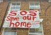 banner hung out of window of house where occupant threatened with eviction