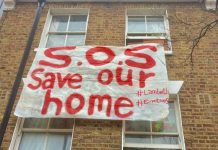 banner hung out of window of house where occupant threatened with eviction