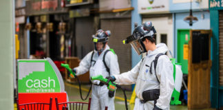 Workers in protective clothing spraying objects