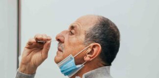 man putting swab in nose