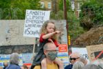 girl on man's shoulders at protest rally