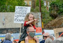 girl on man's shoulders at protest rally