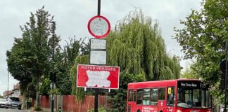 vandalised traffic sign with bus in background