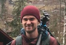 portrait of man outdoors in beanie with camera tripod