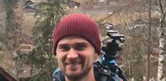 portrait of man outdoors in beanie with camera tripod