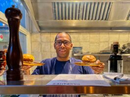 chef at servers hatch with burger