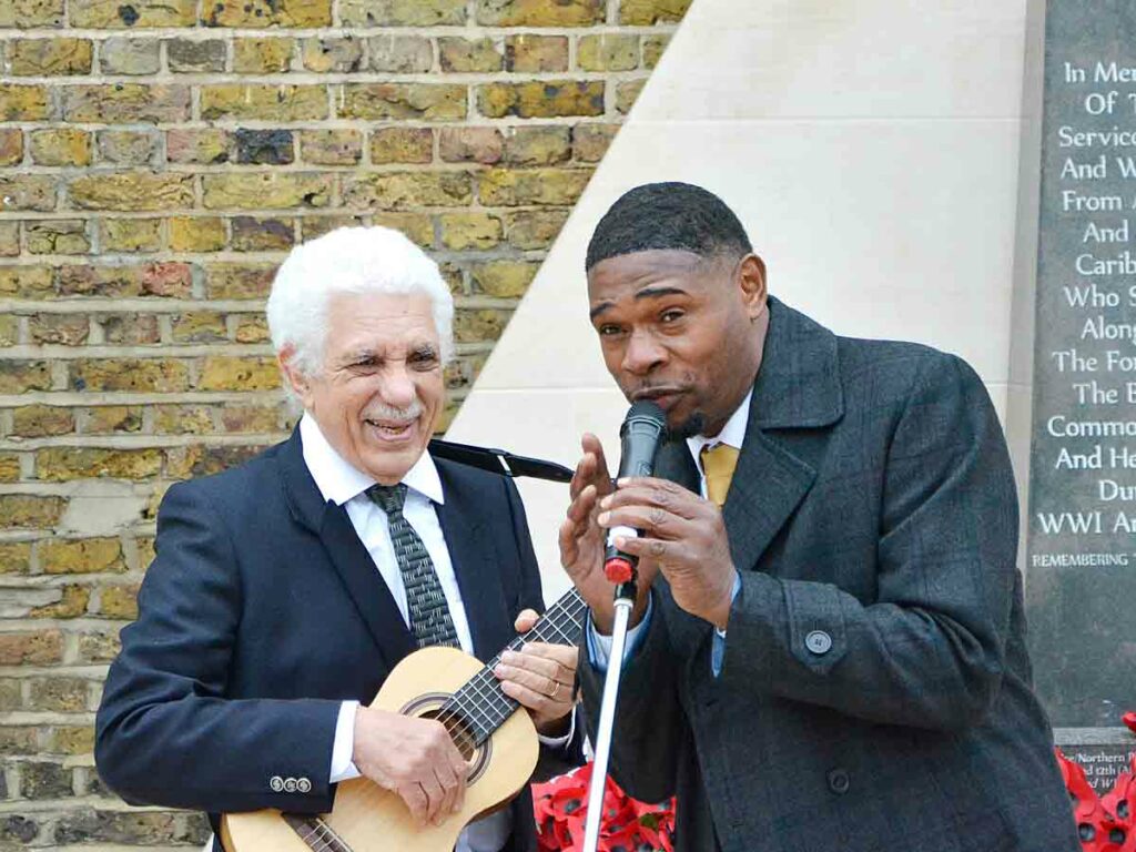 two men sing into mic