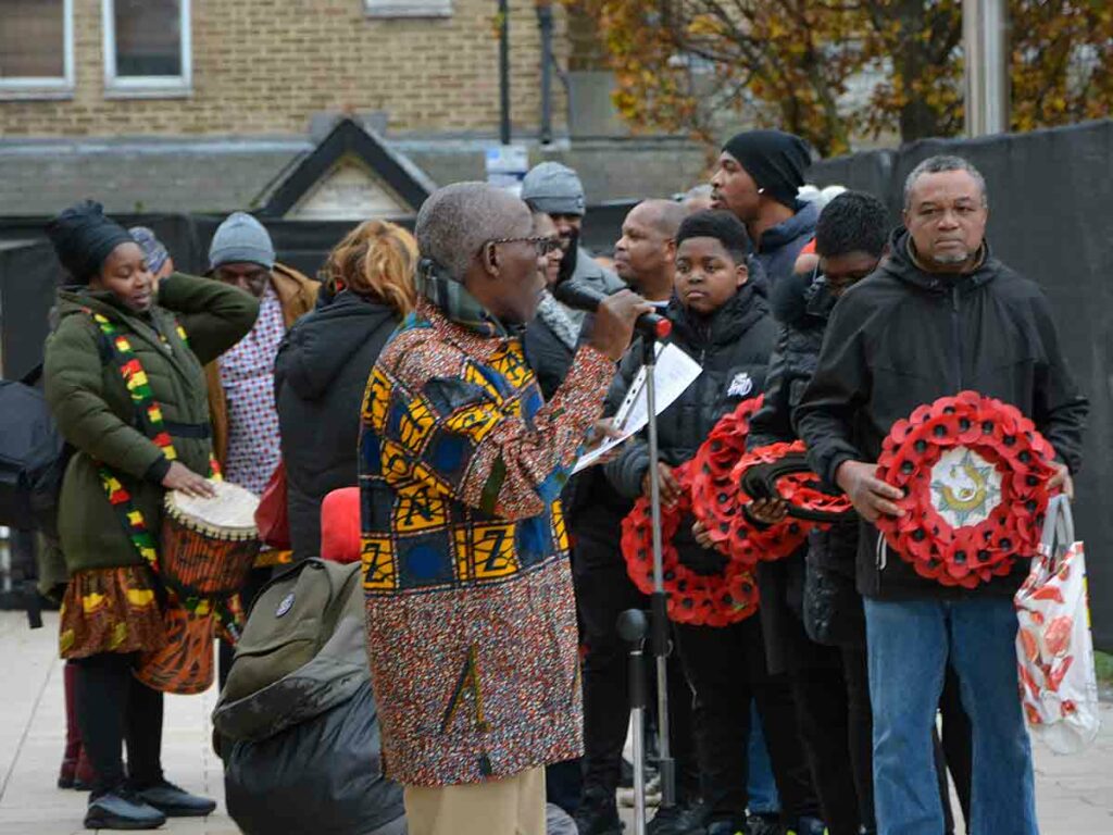 people holding wreaths at open air ceremony