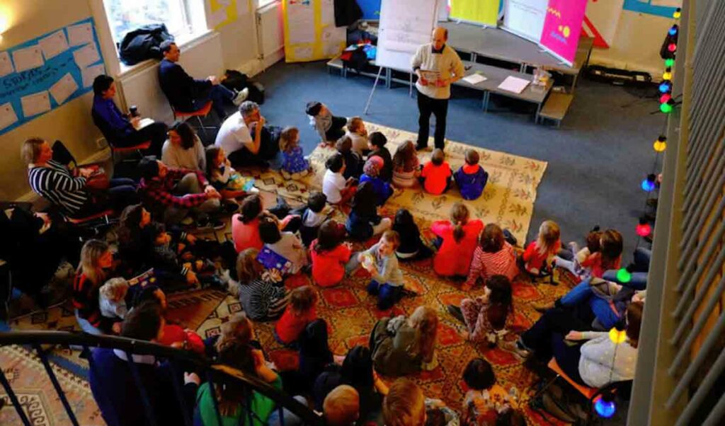 children sitting on floor qt event with adult