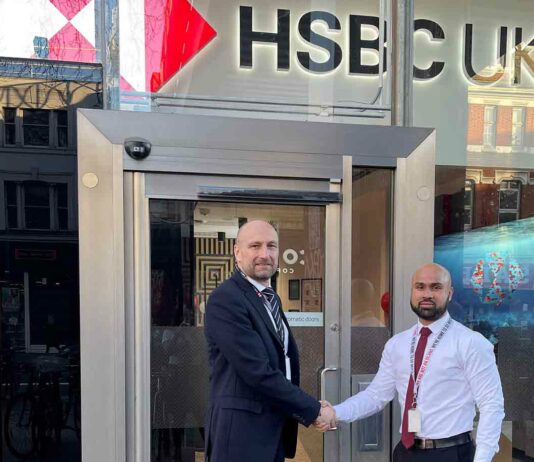 two men pose outside new bank branch