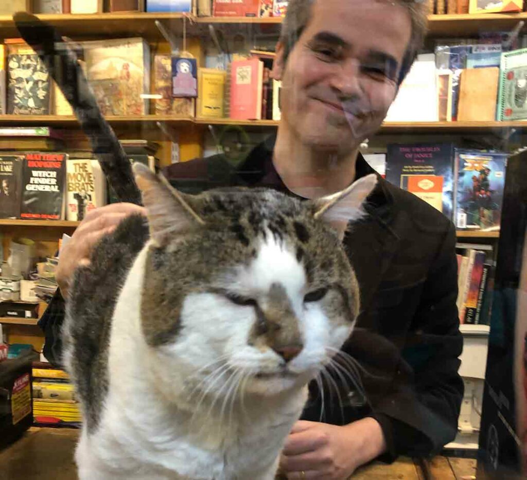 man with cat in bookshop