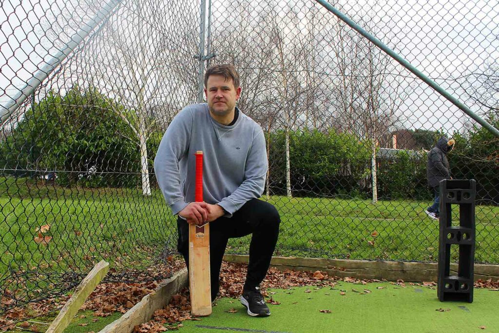 man with cricket bat in nets