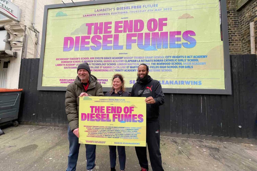 campaigners in front of billboard
