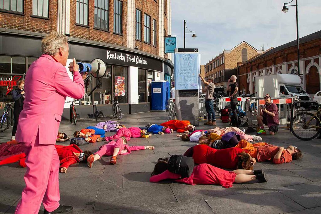 activists dressed in pink lie on pavement