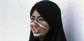 portrait of woman in hijab with football colours on face