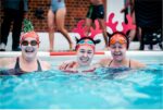 women in swimming pool with reindeer head dress