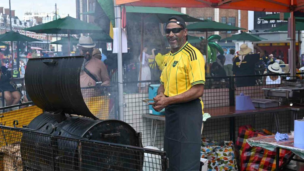 man cooking jerk chicken