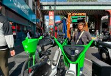 Woman poses for photo with e-bikes