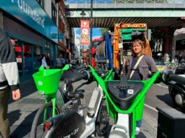 Woman poses for photo with e-bikes