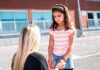 child in playground with teacher