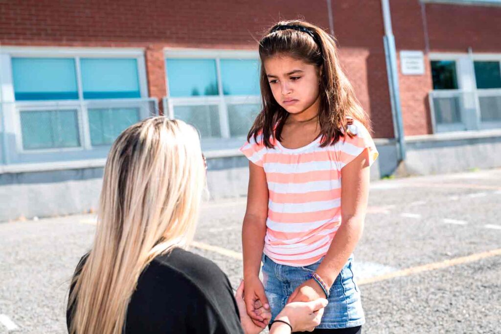 child in playground with teacher