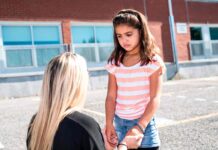 child in playground with teacher