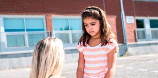 child in playground with teacher