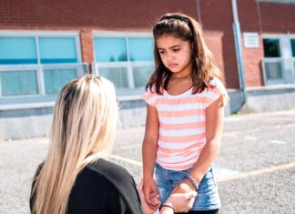 child in playground with teacher