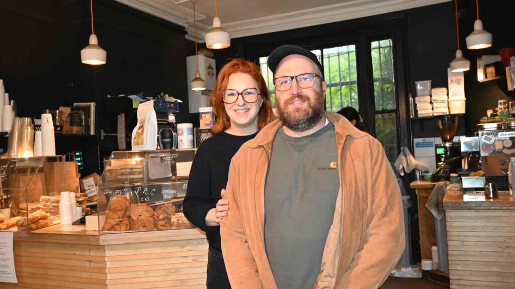 two people pose for photo in a coffee shop
