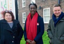 People pose for image in front of social housing