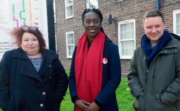 People pose for image in front of social housing